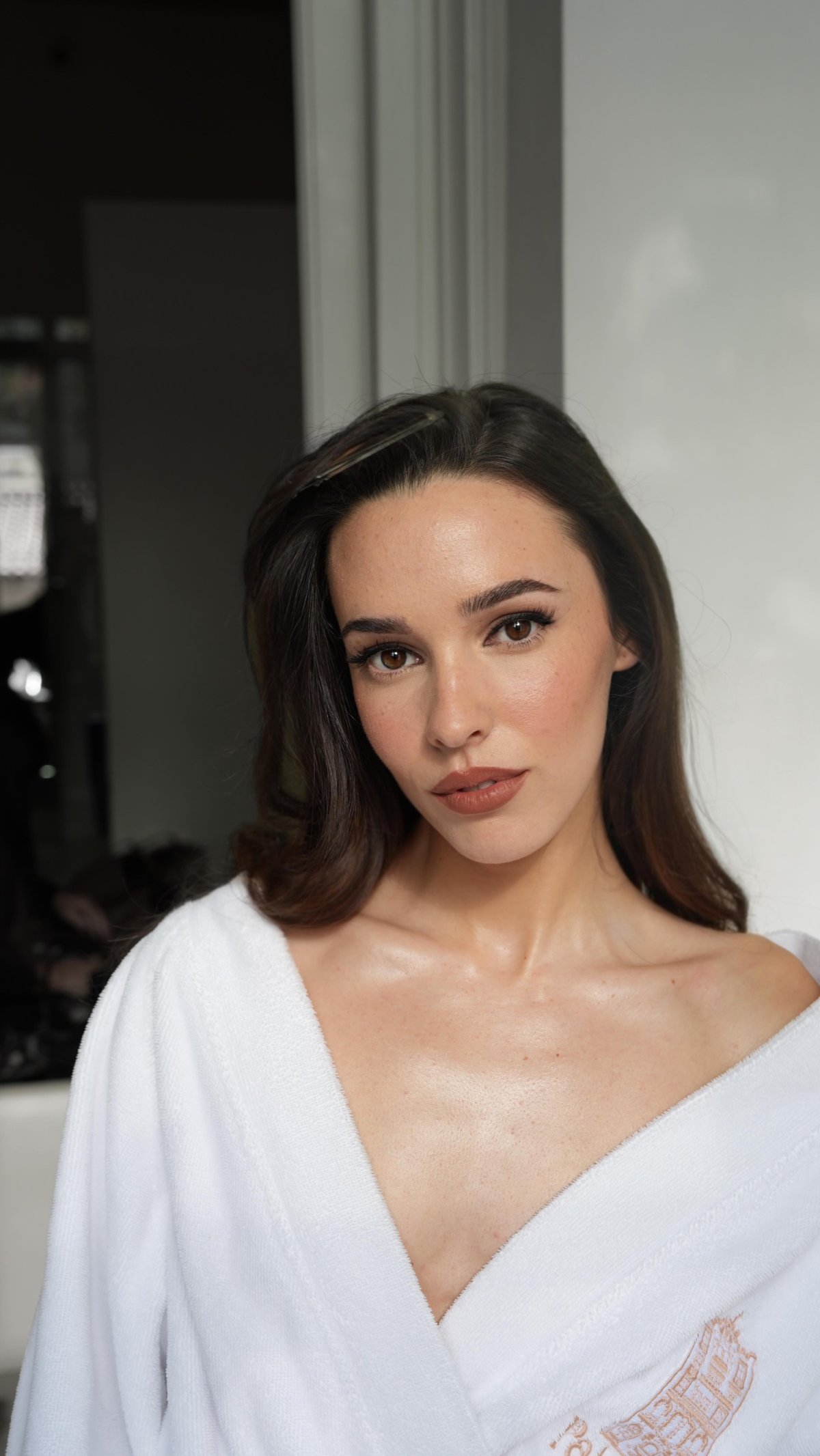 Sara Vidorreta in a white robe after glam, dewy skin and soft brown lip