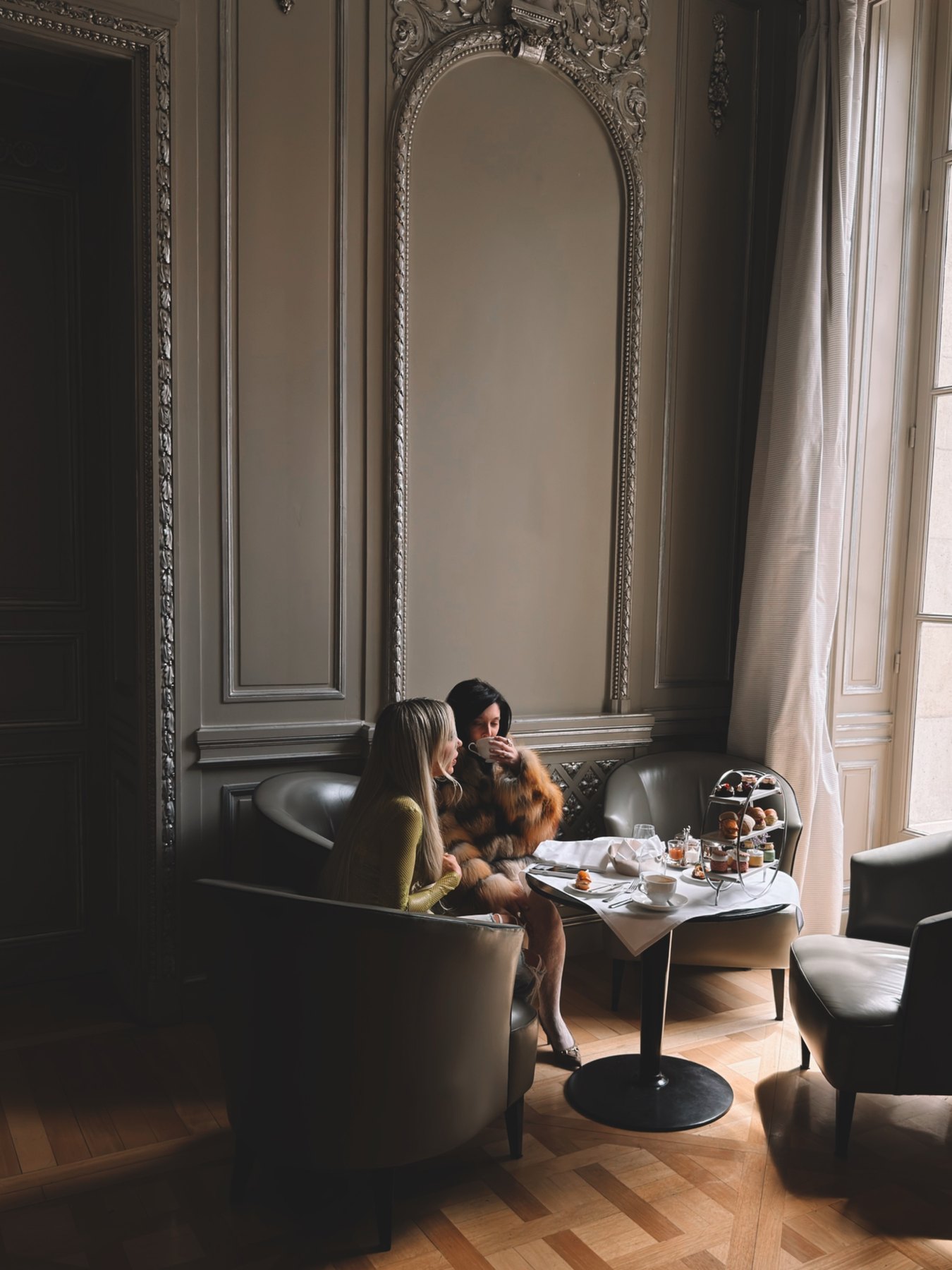 Bad Gyal and Sofía Gonet at afternoon tea in a panelled salon by the window