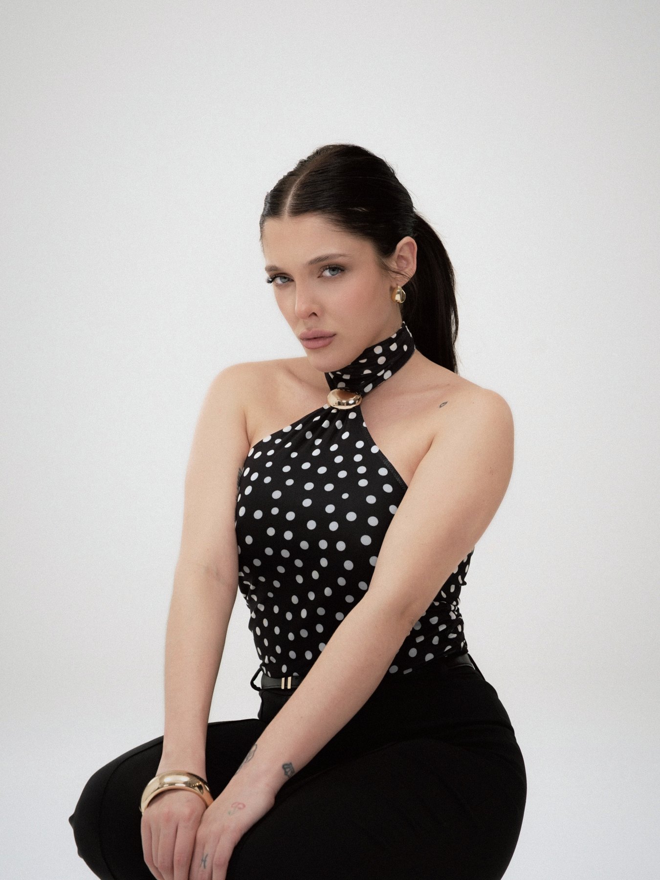 Sofía Gonet seated in the polka-dot halter, direct gaze
