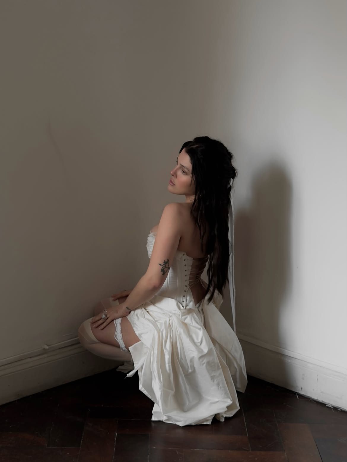 Sofía Gonet crouched in a corner, looking over her shoulder