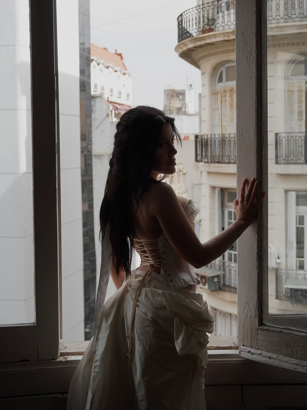 Silhouette of Sofía Gonet from behind at an open window