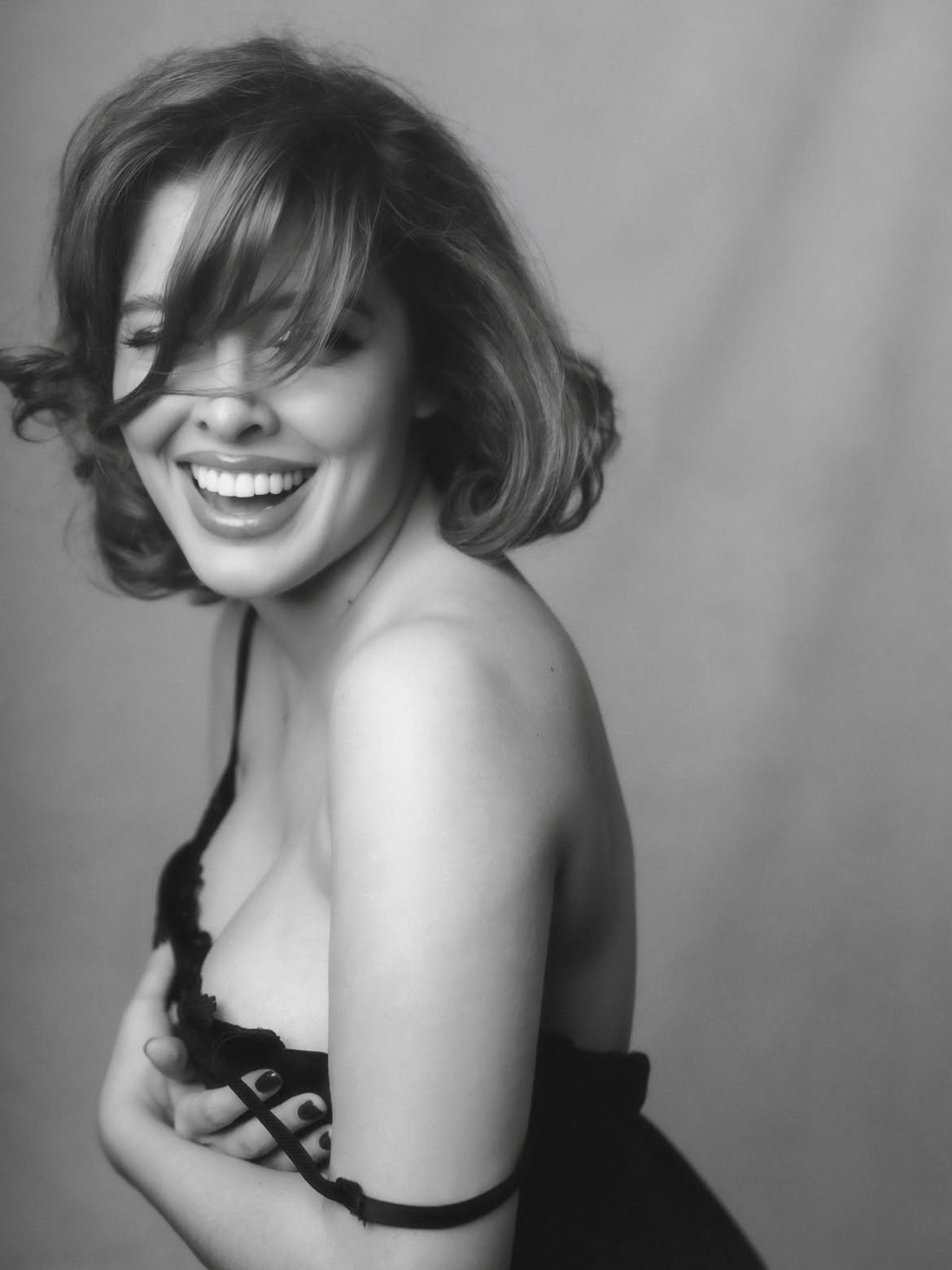 Black and white portrait of Sofía Gonet laughing, hair across her face