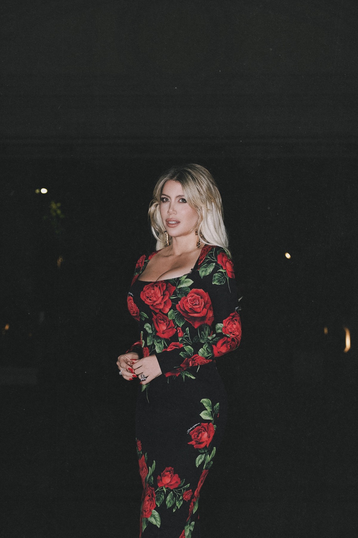 Wanda Nara at night against a black background, flash-lit
